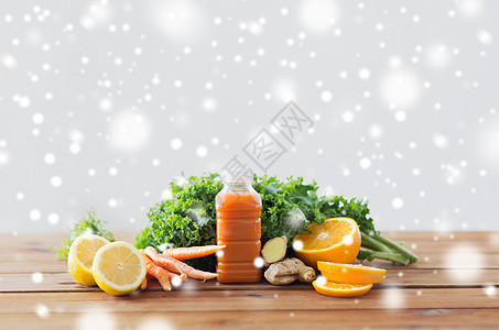 健康的饮食,食物,饮食素食的瓶子与胡萝卜汁,水果蔬菜木桌上的雪装胡萝卜汁水果蔬菜的瓶子图片