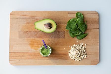婴儿食品,健康饮食营养璃罐与绿色蔬菜泥燕麦片木制切割板木板上果泥婴儿食品的罐子图片