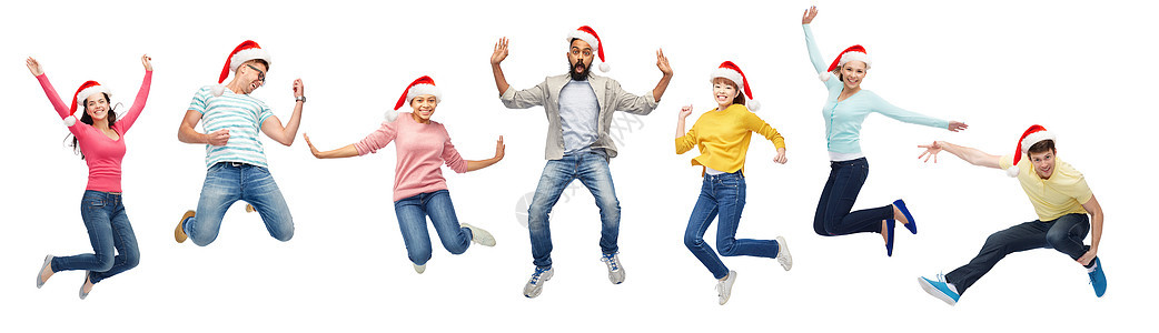 诞节,假日人们的快乐的朋友诞帽空中跳跃穿着诞老人帽子的快乐的人空中跳跃图片