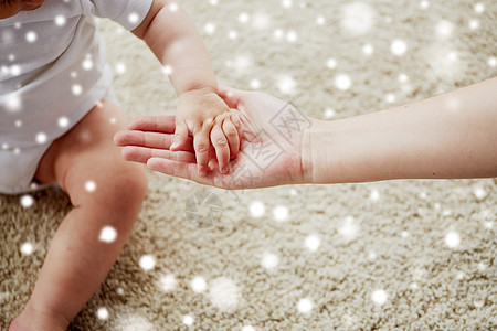 家庭,慈善人的亲密的小婴儿母亲的手雪把小宝宝妈妈的手关来图片