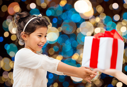 假期,童人的微笑的小女孩灯光背景下给予接受礼物微笑的小女孩送接受礼物图片