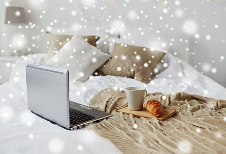 舒适的家,室内冬季舒适的卧室与笔记本电脑,咖啡杯牛角包家里的床上雪笔记本电脑,咖啡牛角包床上舒适的家图片