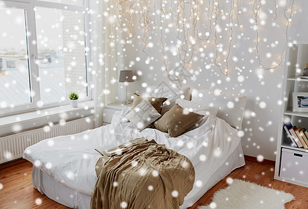 舒适的家庭,室内假日舒适的卧室与床诞花环灯雪上卧室带床诞花环家图片