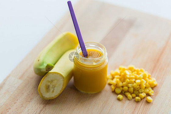 婴儿食品,健康饮食营养璃罐与香蕉果泥玉米木板上罐子里香蕉婴儿食品玉米的罐子图片