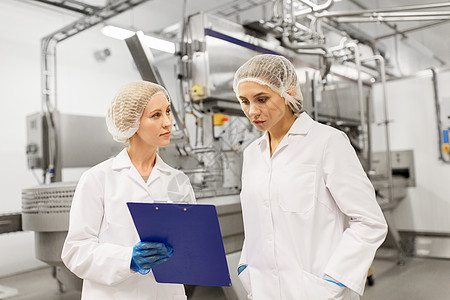 制造,工业人的女技术人员与剪贴板冰淇淋工厂商店冰淇淋工厂的女技术人员背景图片