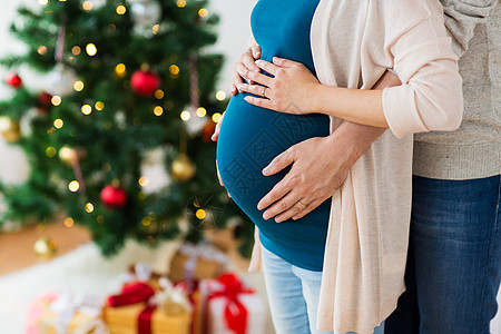 怀孕,寒假人们的接近男人触摸他怀孕的妻子肚子诞节回家男人孕妇诞节回家图片