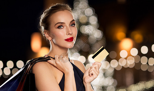 人,奢侈销售美丽的女人与信用卡购物袋诞树灯的背景信用卡购物袋的女人图片