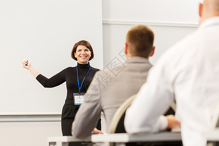 商业,教育人的微笑的女商人讲师与远程群学生会议演示讲座出席商务会议讲座的群人图片