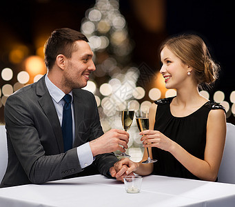 庆祝,人节日的微笑的夫妇诞树背景下的餐厅碰杯非酒精泡酒诞节含酒精的香槟图片