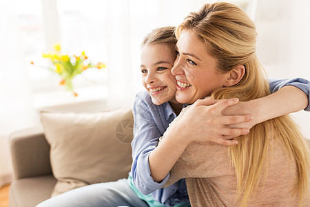 人们家庭的快乐的微笑女孩母亲拥抱沙发上家幸福微笑的家人家里沙发上拥抱图片