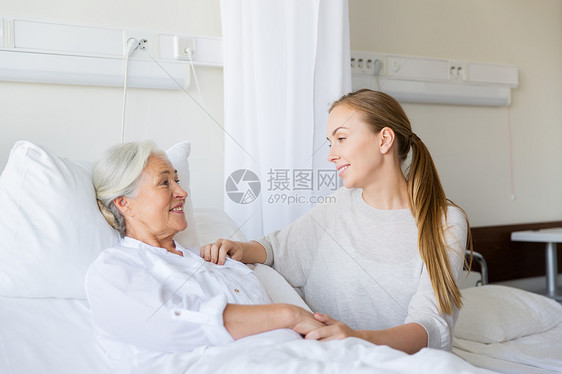 医学,家庭,医疗人的女儿拜访欢呼她的母亲躺医院病房的床上女儿医院看望迈的母亲图片