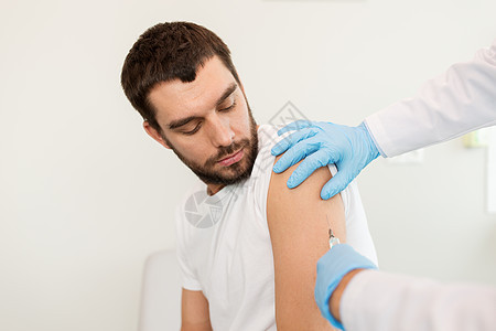 药物疫苗接种保健医生护士用注射器给男病人注射疫苗男病人医生用注射器的手图片