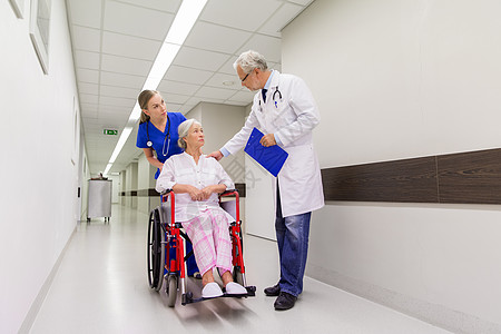 医疗保健人的医生护士轮椅上的老妇女病人医院走廊诊所坐轮椅的医生高级病人图片