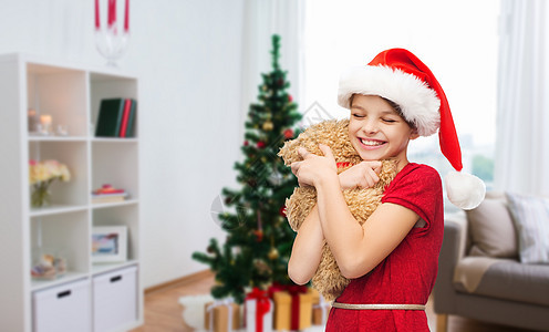 诞节,假日人们的快乐的微笑女孩诞老人帮助帽子与泰迪熊家里诞节泰迪熊的快乐女孩图片