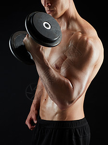 运动,健美,健身人的接近轻人与哑铃弯曲肌肉黑色背景用哑铃锻炼的人的特写图片