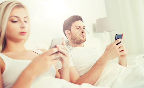 人,技术,互联网通信与智能手机床上夫妇床上智能手机图片