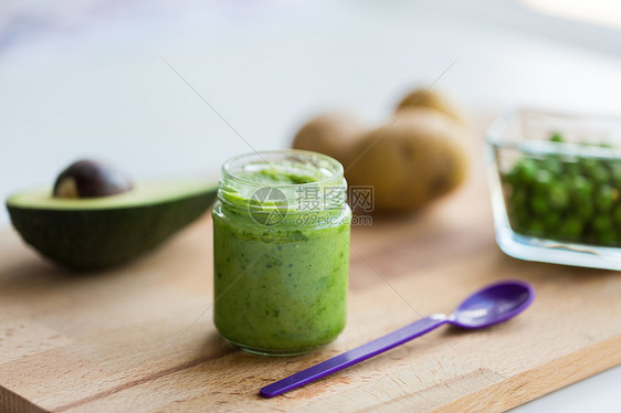 婴儿食品,健康饮食营养璃罐与绿色素泥木制切割板木板上果泥婴儿食品的罐子图片