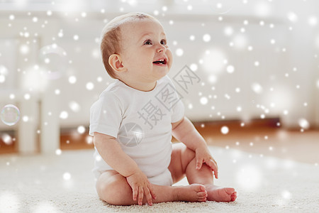 童,婴儿期人们的快乐的小男孩女孩坐地板上,家里的雪上肥皂泡家里肥皂泡的快乐宝宝背景图片