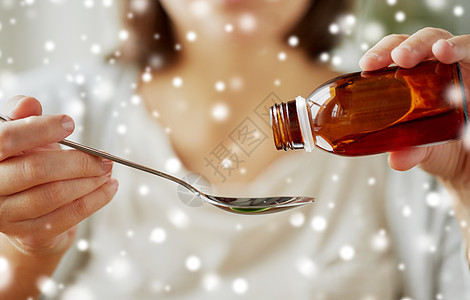 医疗保健,人医学妇女倒药解热糖浆瓶子勺子雪上女人把药物瓶子里灌勺子里图片
