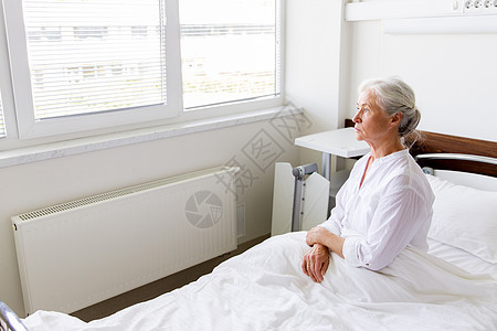 医学,医疗老人的悲伤的老妇女坐医院病房的床上悲伤的老妇女坐医院病房的床上图片