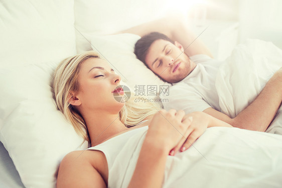 幸福的夫妇睡家里的床上图片