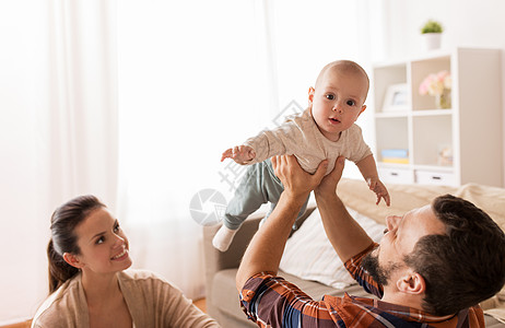 家庭,父母人的快乐的母亲父亲家里玩婴儿快乐的母亲父亲家里婴儿玩耍图片