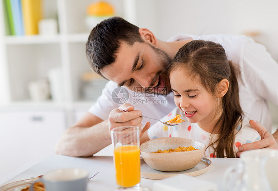 家庭,饮食人的快乐的父亲女儿家吃薄片早餐幸福的家庭家里吃薄片早餐图片