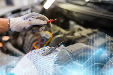 汽车服务,维修,维护人的汽车技工与数字万用表测试电池车间汽车机械师与万用表测试电池图片