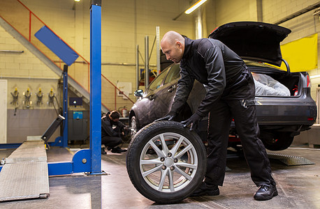 汽车服务,维修,维护人的汽车机械师更换轮胎车间汽车机械师车间更换汽车轮胎图片