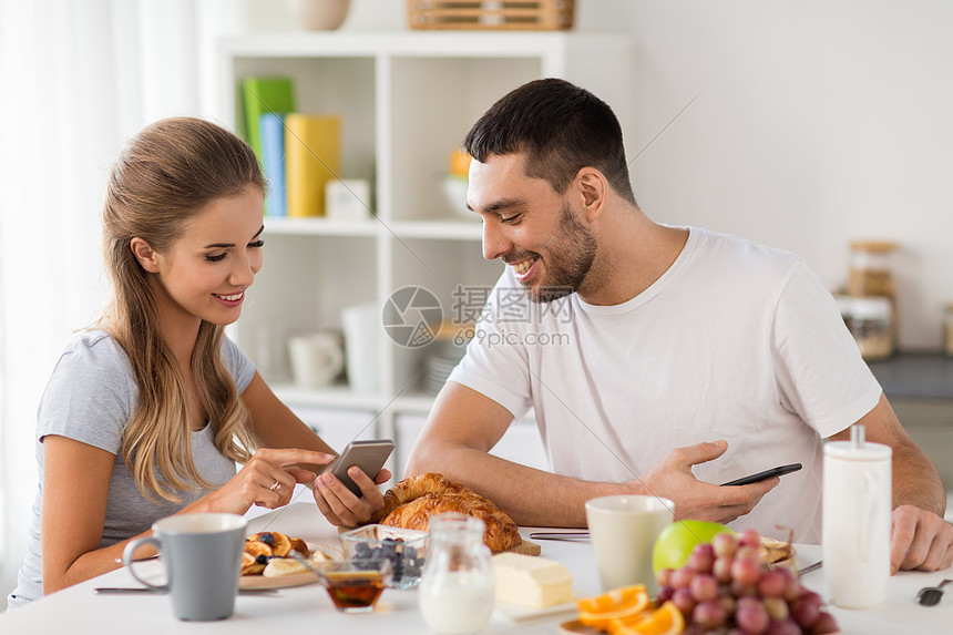 技术,饮食人们的幸福的夫妇与智能手机家里吃早餐夫妇带着智能手机家吃早餐图片