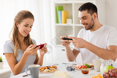 技术,饮食人们的幸福的夫妇与智能手机家里吃早餐夫妇带着智能手机家吃早餐图片