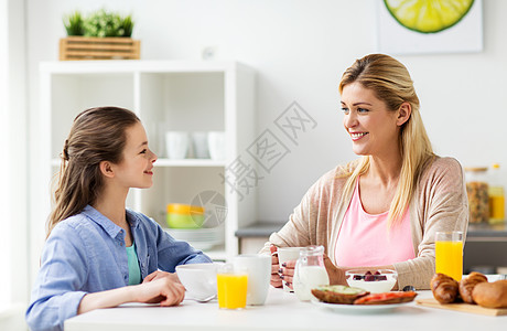 健康饮食,家庭人的快乐的母亲女儿家里的厨房吃早餐幸福的家庭家里的厨房吃早餐图片