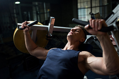 运动,健身,健美人的男人胸部按压健身房的运动机器健身房锻炼机器上胸部按压的男人图片