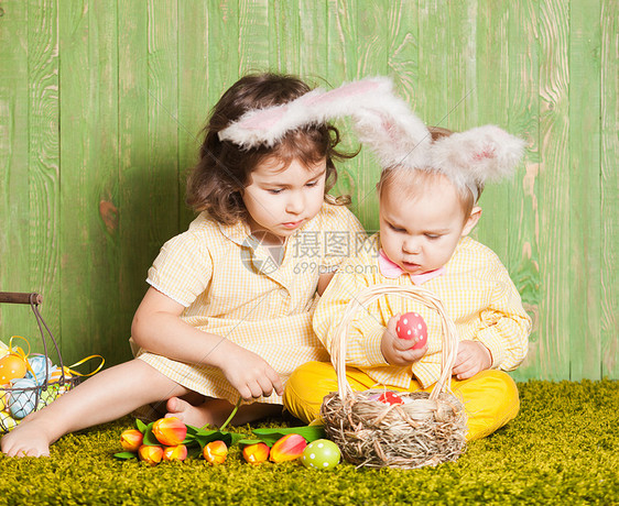 小男孩女孩复活节兔子草地上用五颜六色的鸡蛋复活节兔子宝宝图片