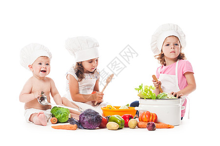 三个孩子玩蔬菜小厨师白色上隔离小厨师饭图片