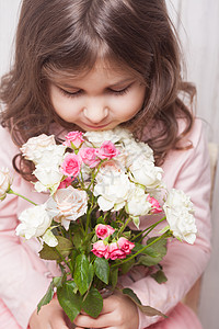 粉红色的小漂亮女孩着玫瑰花把花脸闭上带玫瑰的女孩图片