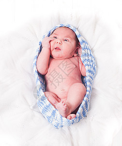 新生的婴儿编的茧中的柔软的白色毯子上新生儿图片