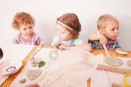 可爱的孩子们幼儿园用灰色的塑料雕刻些东西快乐的孩子们事造型粘土图片