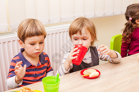 孩子们坐桌子旁吃午饭,吃水果蛋糕幼儿园吃午饭图片