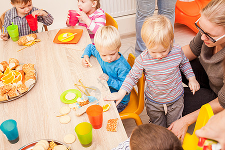 孩子们坐桌子旁吃午饭,吃水果蛋糕幼儿园吃午饭图片