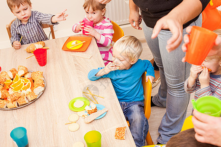 孩子们坐桌子旁吃午饭,吃水果蛋糕幼儿园吃午饭图片