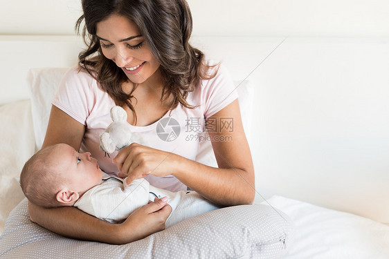 轻的母亲带着婴儿床上图片