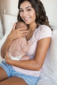 可爱的母亲抱着新生的婴儿图片