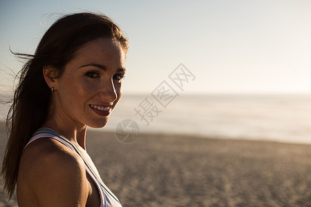海滩上享受美丽日落的女人的肖像图片