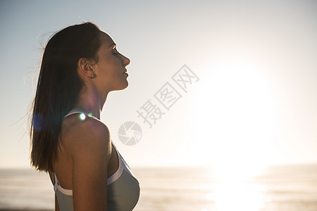 海滩上享受美丽日落的女人的肖像图片