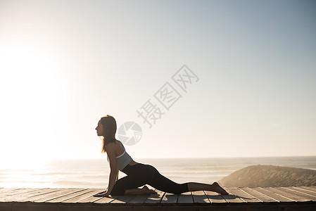 健身妇女海滩上享受美丽的日落图片