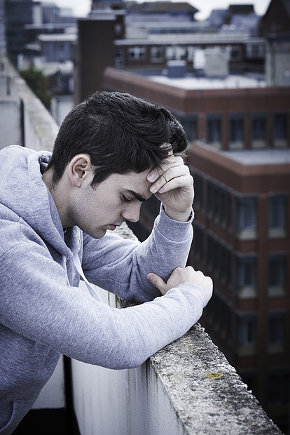 沮丧的轻人高楼顶上考虑自