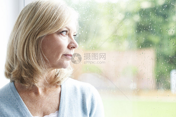 悲伤成熟的女人患广场惧症,望着窗外图片