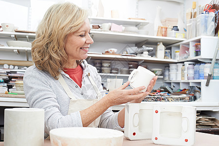 成熟的女人陶器工作室铸造杯子图片