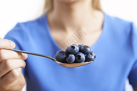 用勺蓝莓接近女人图片